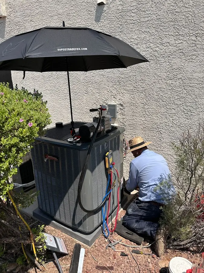 HVAC technician performing outdoor AC maintenance in The Meadows